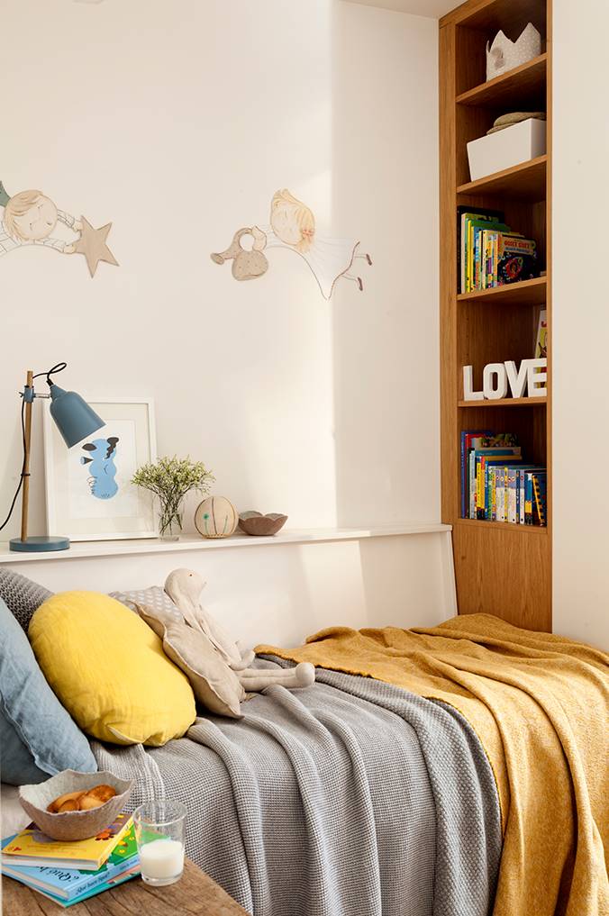 Una habitación infantil pequeña con una cama y con una repisa en la pared a modo de mesita de noche.