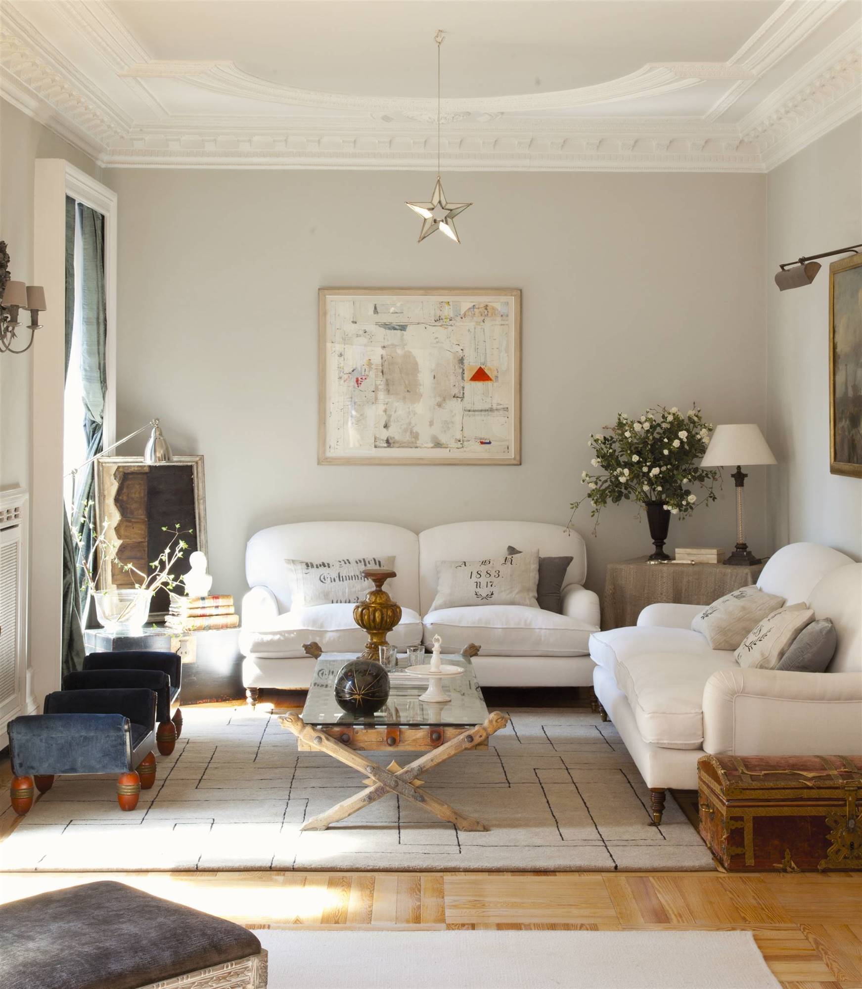 Salón con sofás blancos y paredes beige. 