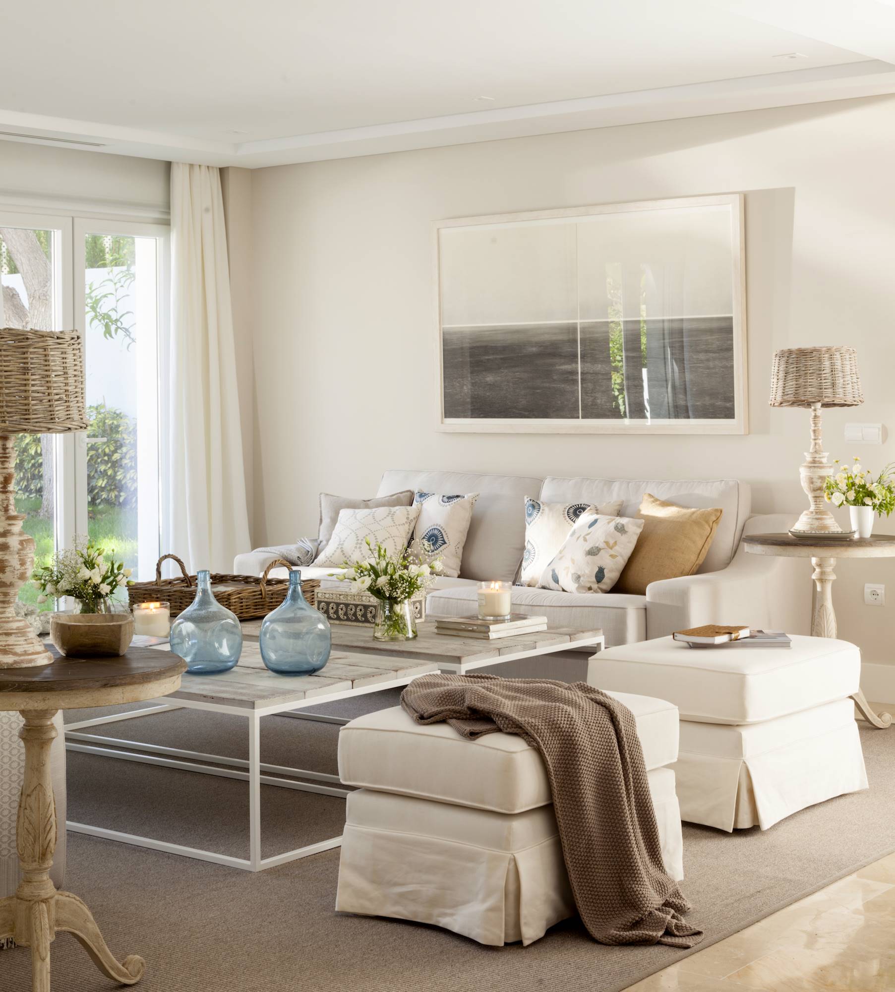Salón con paredes, sofá y butacas de color beige. 