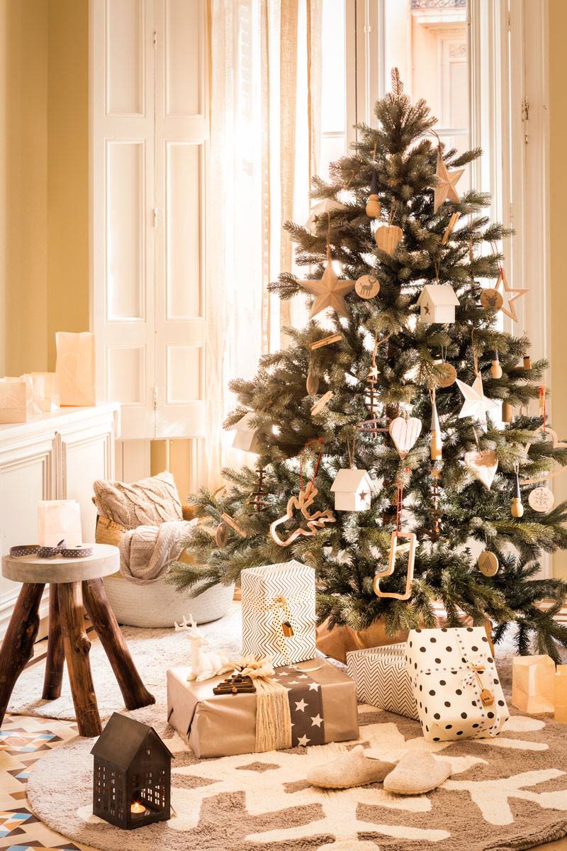 Salón de estilo nórdico en blanco y gris con árbol de Navidad.