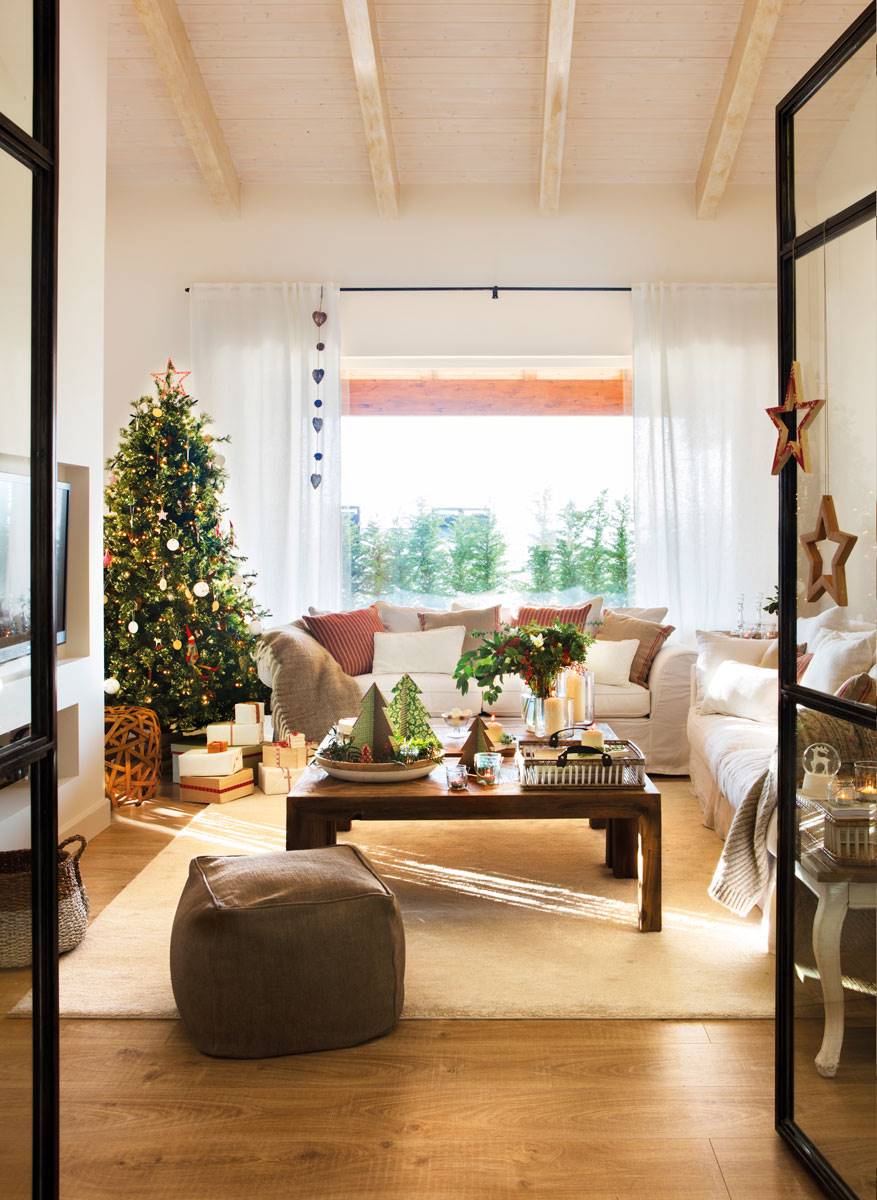 Salón moderno con mesa de centro de madera, alfombra, chimenea y árbol de Navidad.