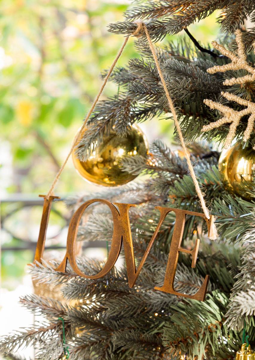 Árbol de Navidad con adornos de mensajes dorados. 