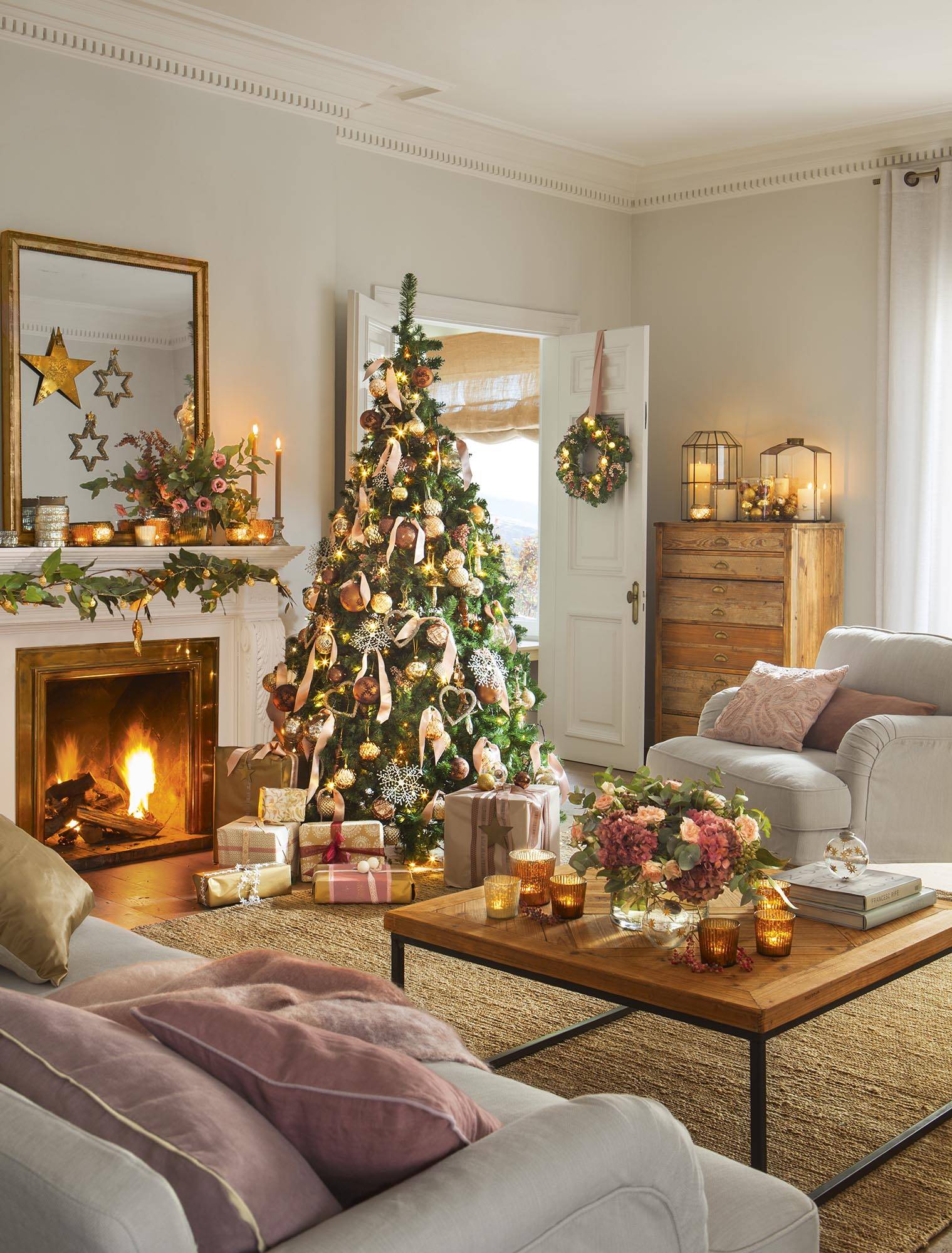 Salón clásico con alfombra de fibras, mesa de madera, chimenea y árbol de Navidad iluminado. 