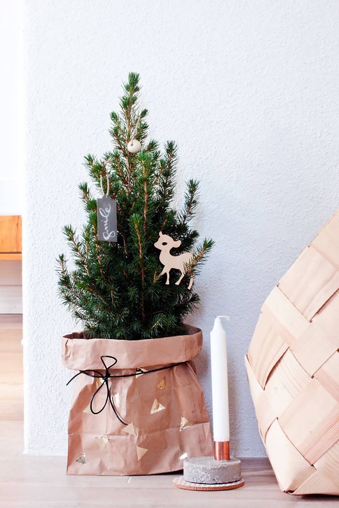 Árbol de Navidad con pie del árbol decorado con una bolsa de cartón.