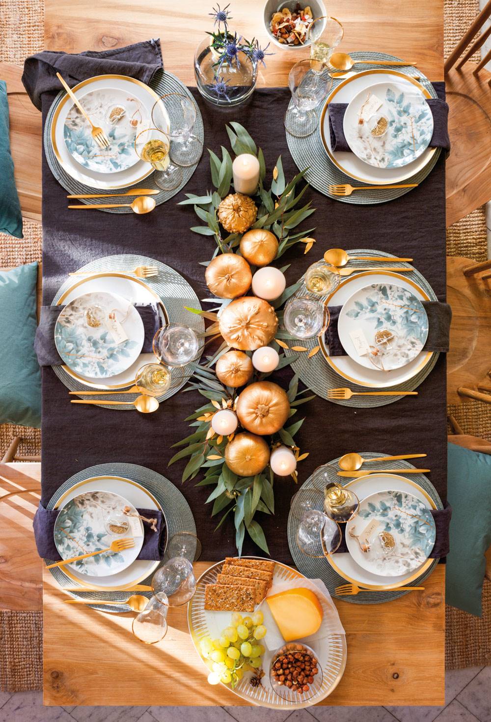 Vista cenital de mesa de Navidad con camino de mesa con calabazas doradas