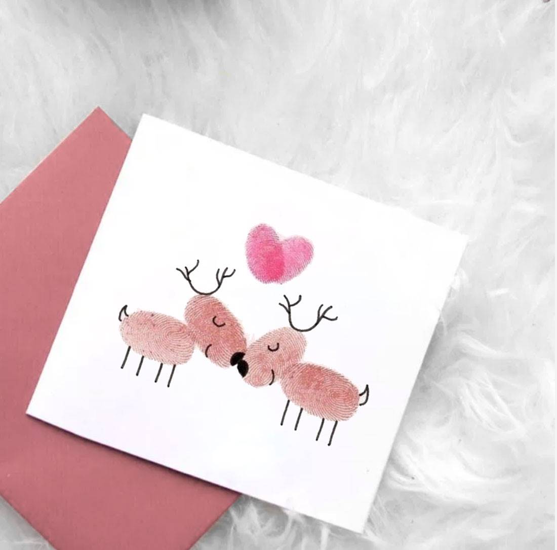 La tarjeta de Navidad rosa hecha con pintura en el dedo. 
