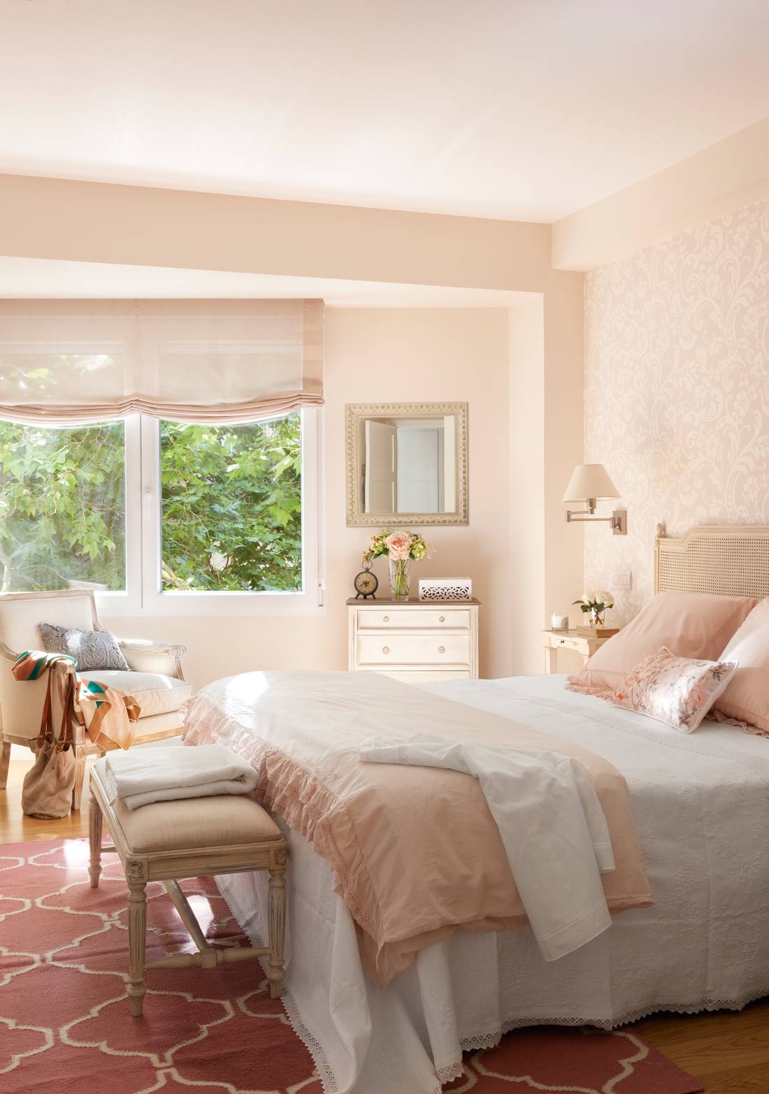 Dormitorio con ropa de cama blanca y rosa. 