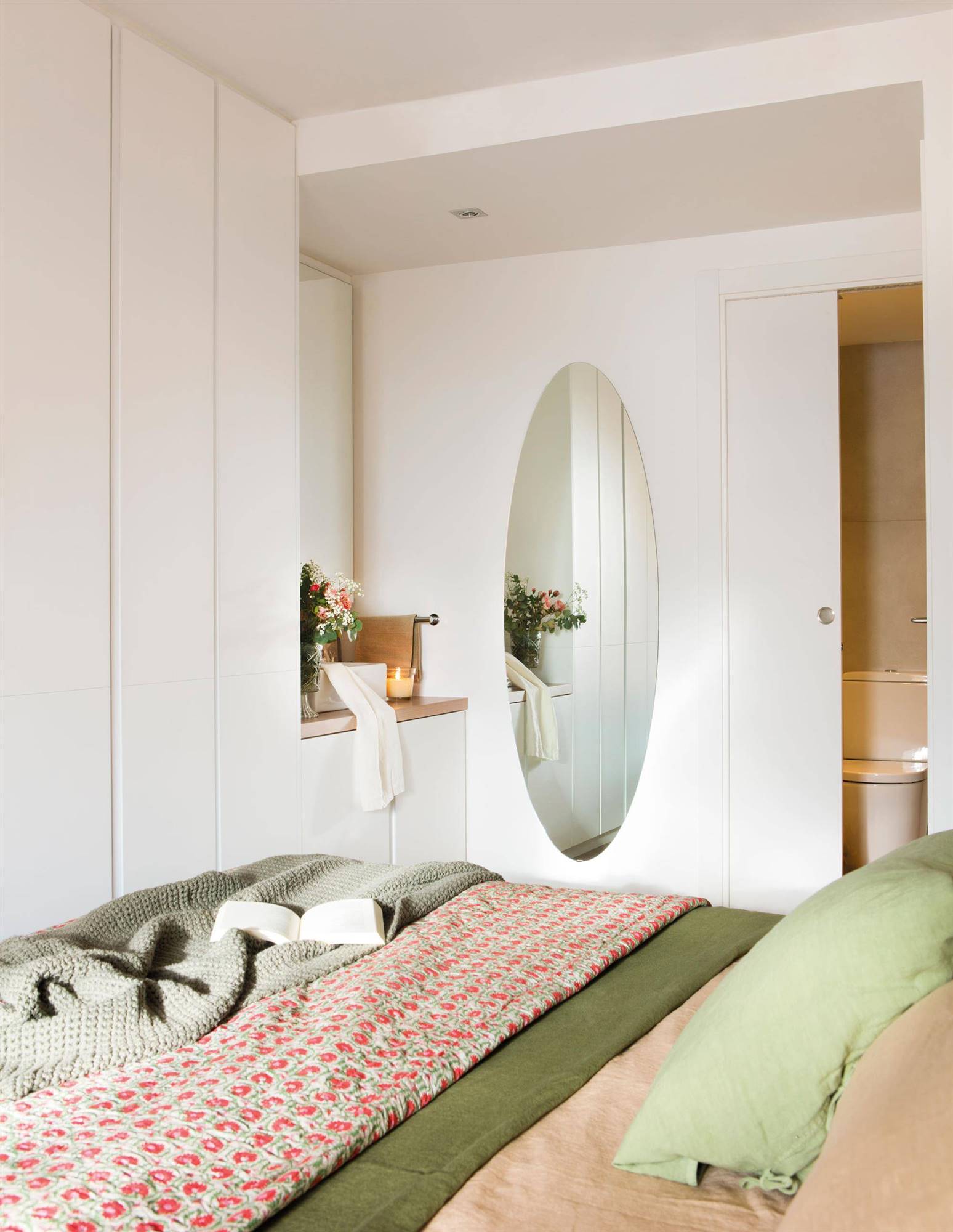 Dormitorio con espejo ovalado.
