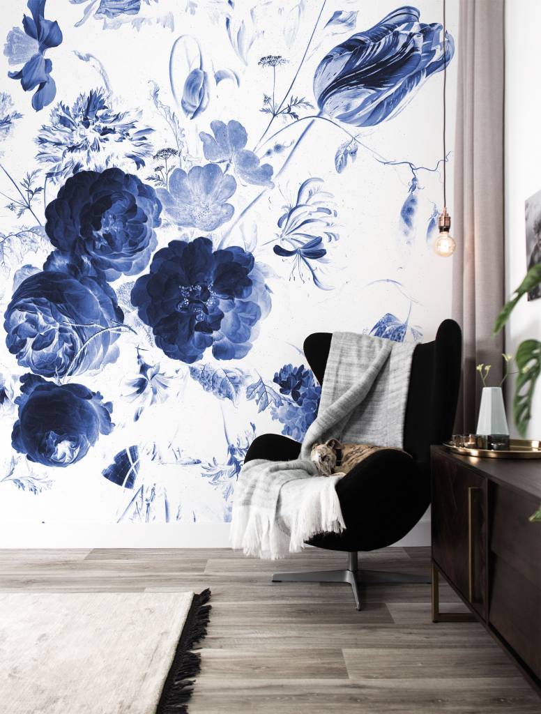 Habitación con butaca negra y wall mural de flor azul.