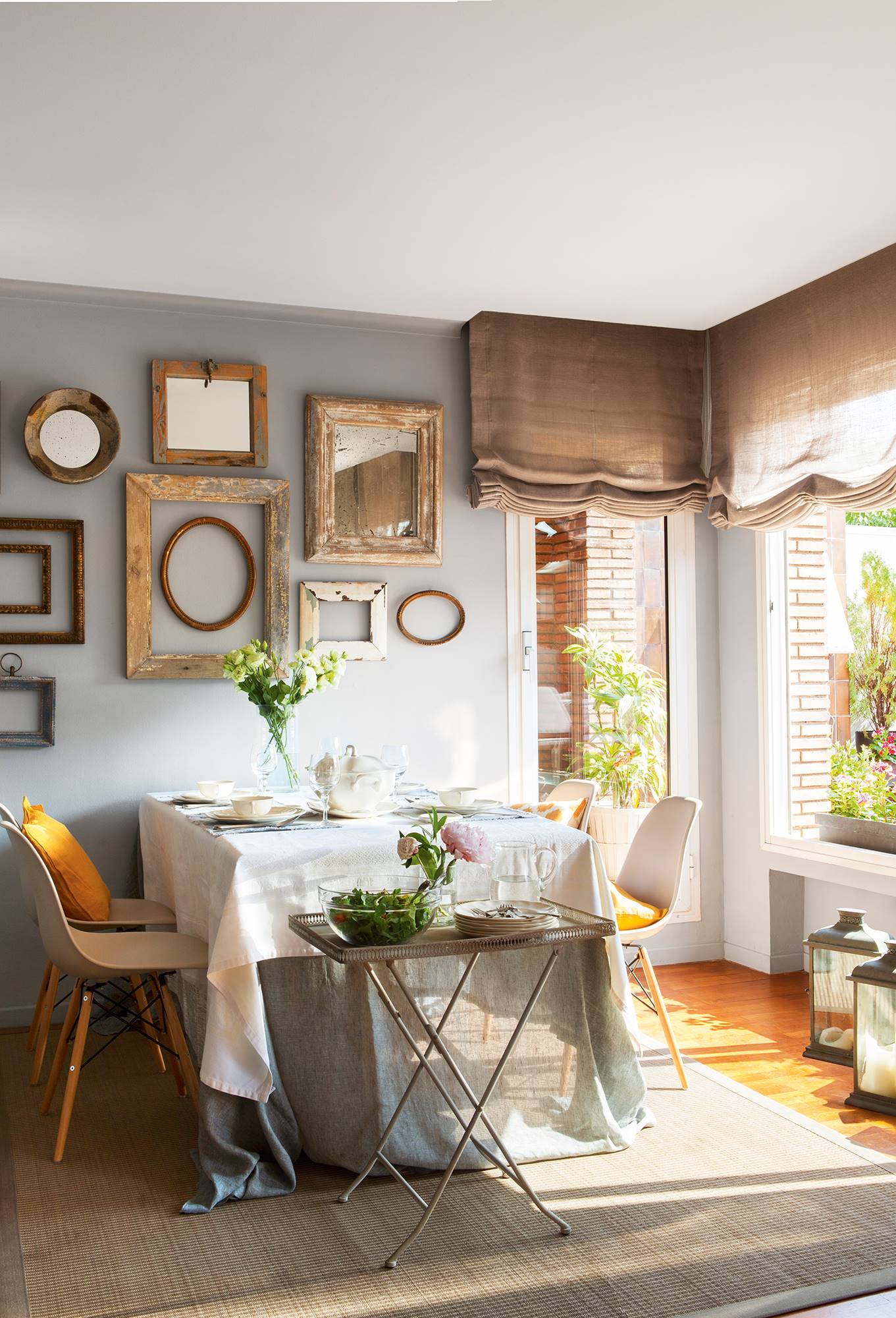 Comedor con mesa, sillas, mesa auxiliar y marcos decorando la pared.