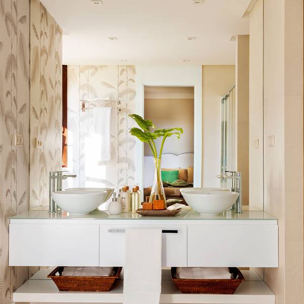 Baño con lavamanos doble, mueble bajolavabo volado y paredes con papel pintado