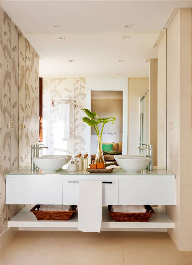 Baño con lavamanos doble, mueble bajolavabo volado y paredes con papel pintado