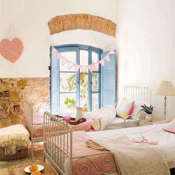 candida y dulce habitacion-infantil-con-dos-camas-en-paralelo-y-paredes-de-piedra