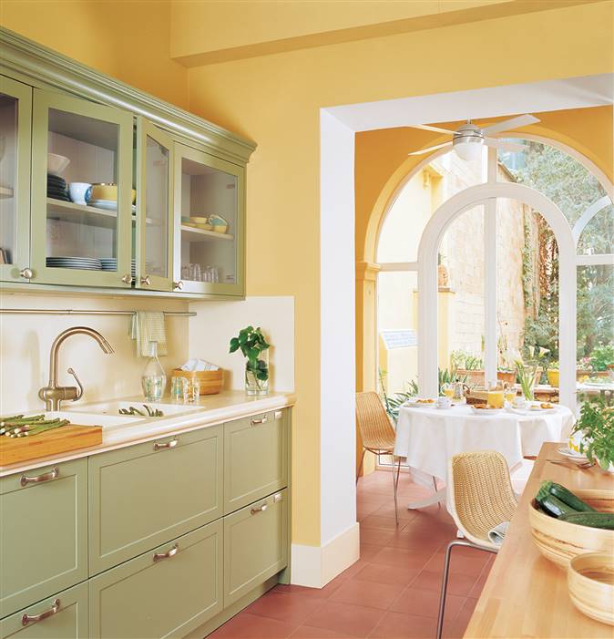 Cocina de pared color amarillo y mobiliario en verde