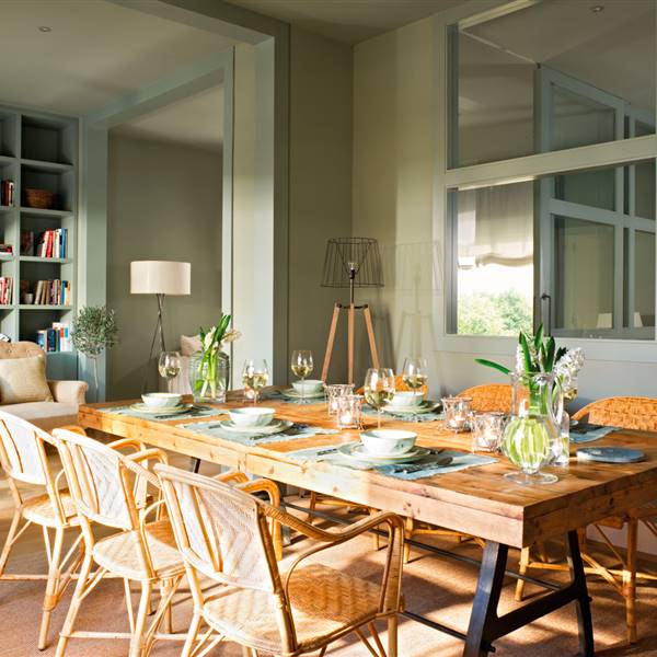 Comedor con paredes de color verde, mesa y sillas de madera natural y pared con cuarterones de cristal_00342791