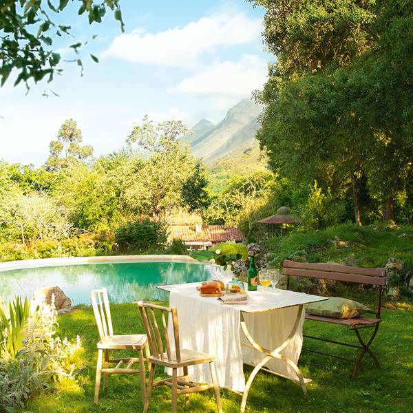 Comedor en jardín con piscina y vistas a la montaña