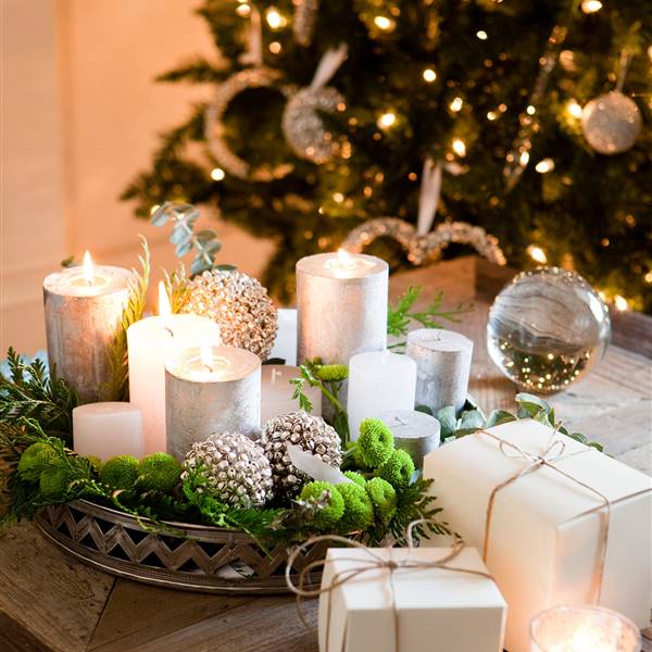 Detalle de centro de mesa de Navidad hecho con bolas con cascabeles y velas