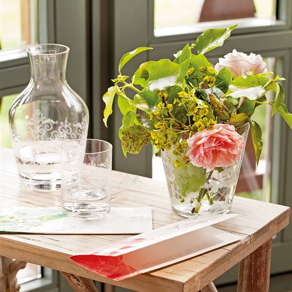 Detalle de jarrón con flores sobre mesa auxiliar