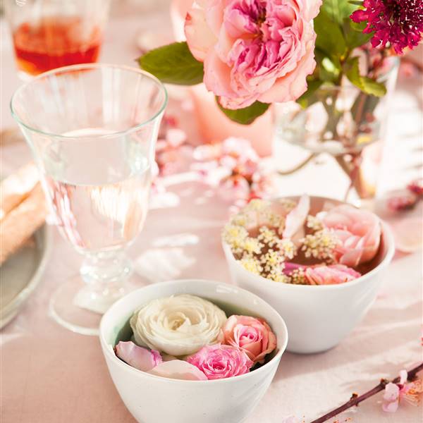 Detalle mesa flores rosas y vajilla blanca