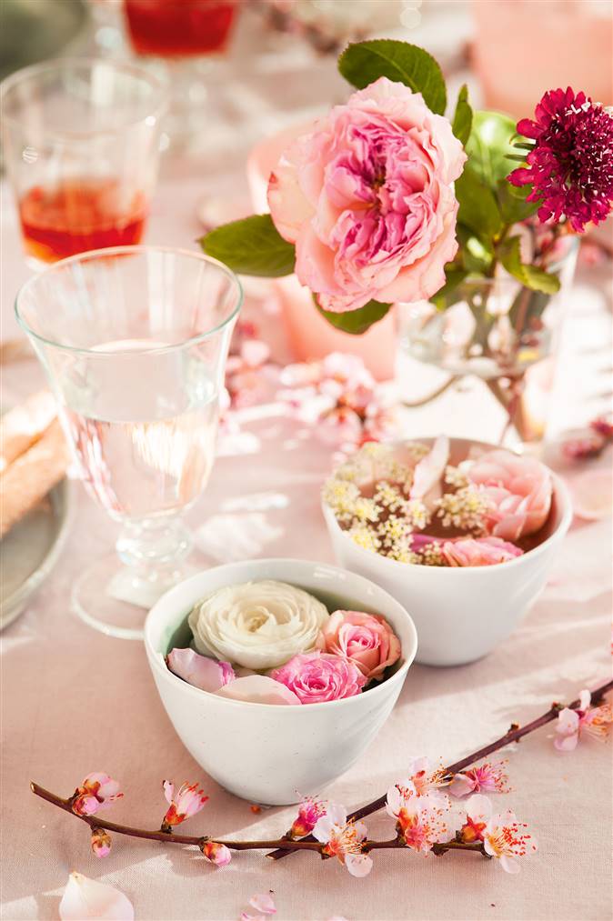 Detalle mesa flores rosas y vajilla blanca