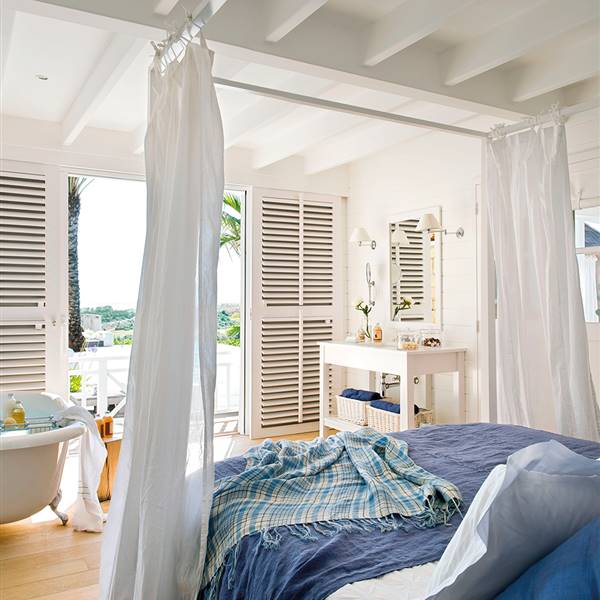 Dormitorio con baño en tonos blancos y azules