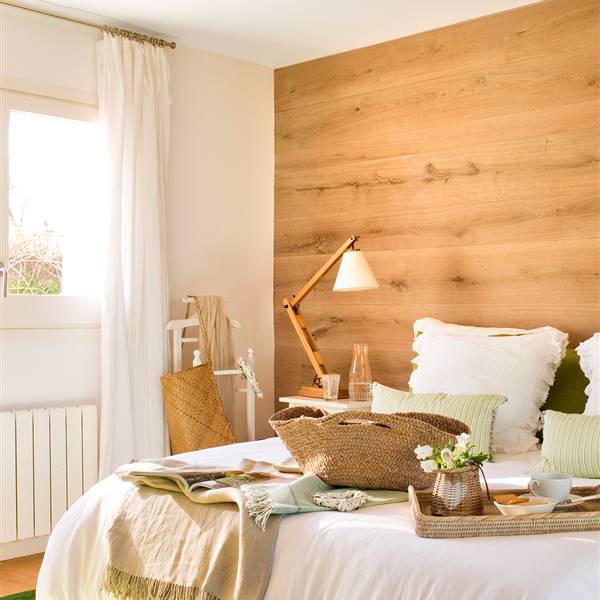 Dormitorio con cabecero de madera que abarca toda la pared