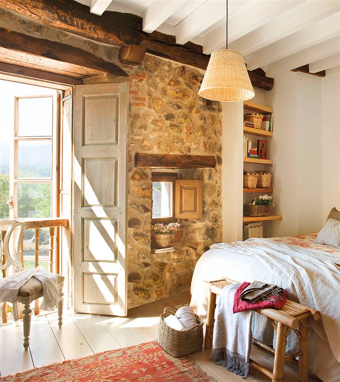 Dormitorio con pared de piedra vista