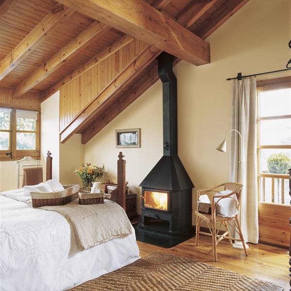 Dormitorio con techo abuhardillado de madera, suelo de parquet, estufa o chimenea y alfombra de fibra natural_151014