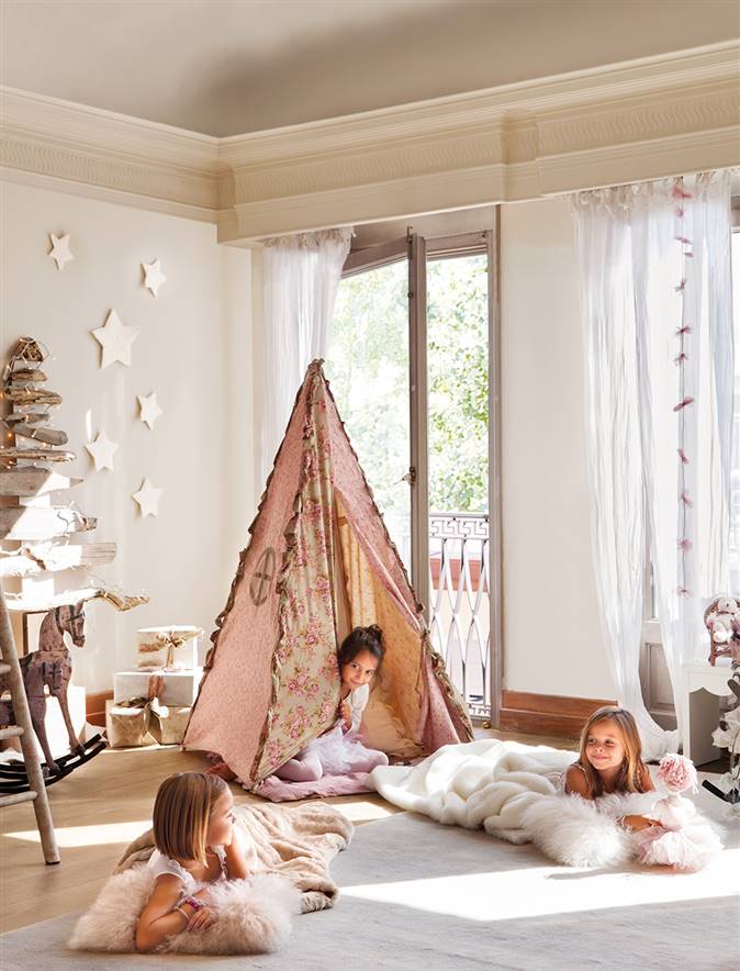 Dormitorio con tienda confeccionada con telas vintage y tres niñas