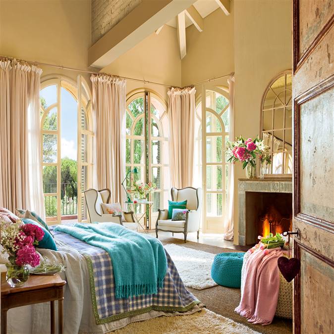 Dormitorio con ventanales de vidrieras en arco y toques de color