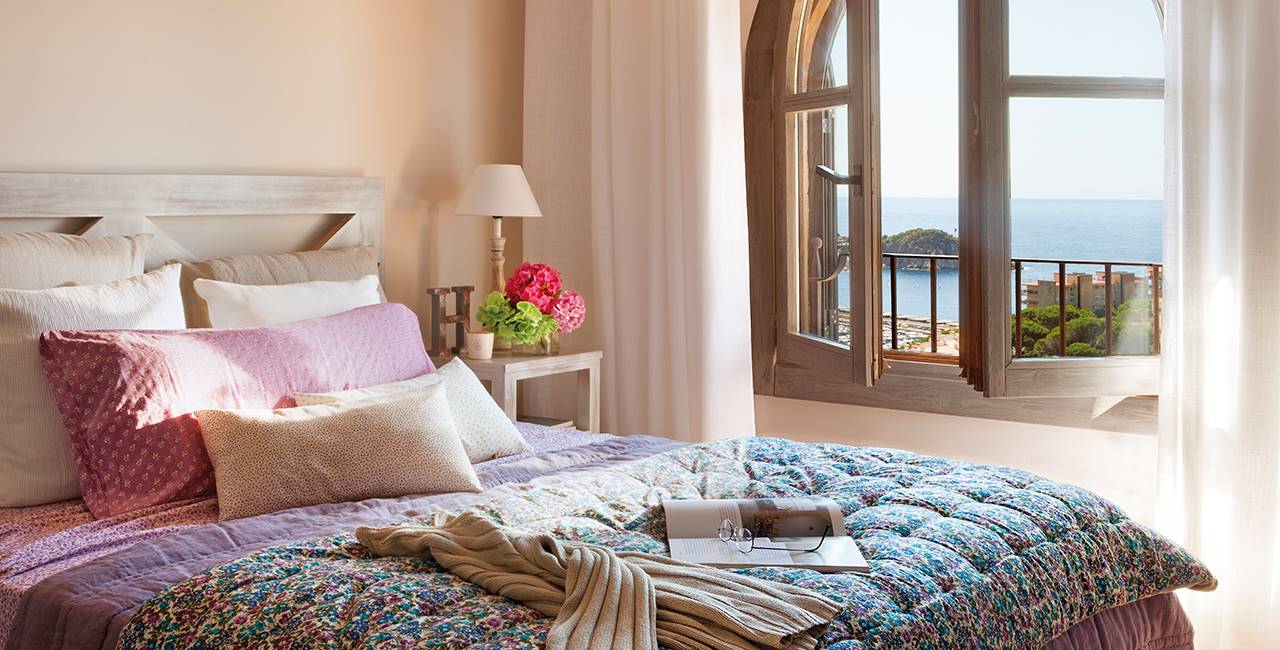Dormitorio con ventanas de arco y vistas al mar