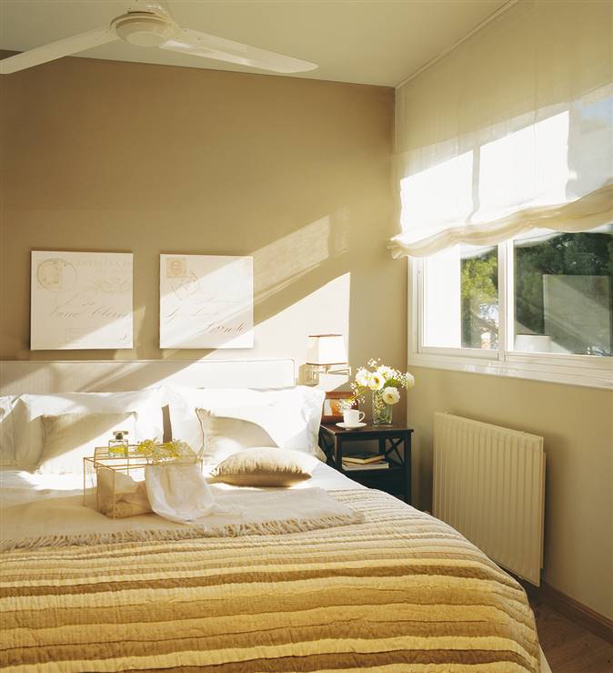 Dormitorio con ventilador de techo y pared en color piedra