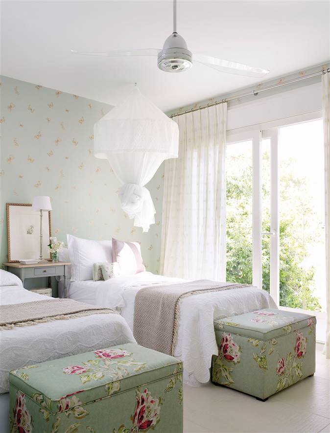 Dormitorio empapelado en turquesa con banquetas de flores