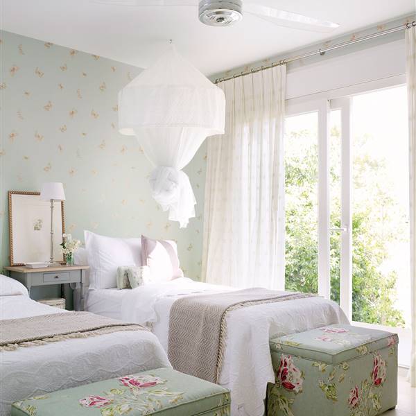 Dormitorio empapelado en turquesa con banquetas de flores