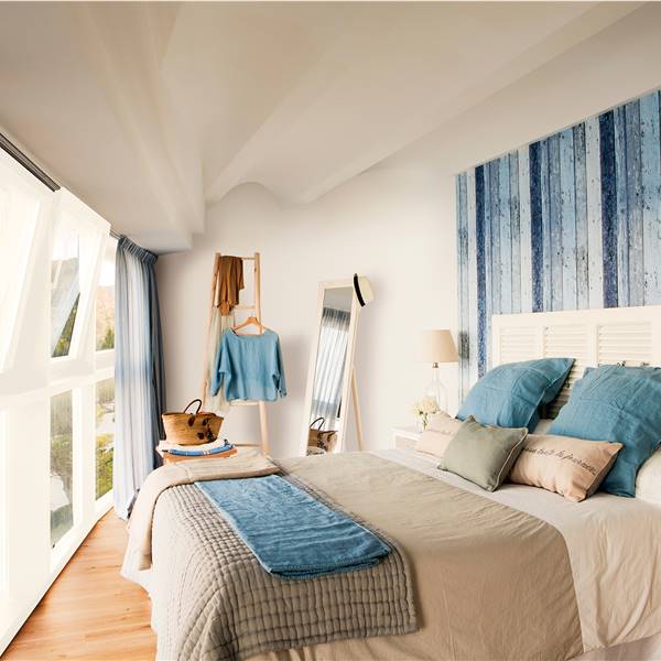 Dormitorio en blanco y azul con gran ventanal a pie de cama