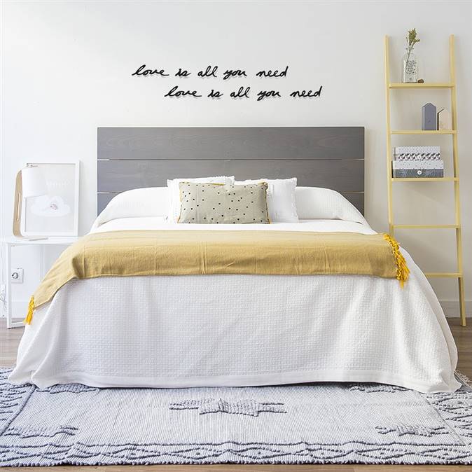 Dormitorio en grises y amarillos con mensaje de amor en la pared