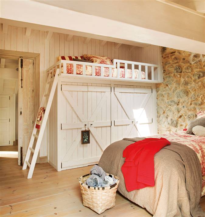 Dormitorio infantil de estilo campestre con dos camas, una alta sobre un armario