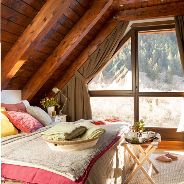 Dormitorio rústico con teho de madera y ventana al bosque