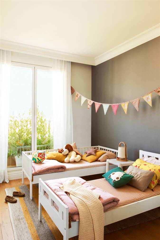 Habitación infantil con dos camas y una pared pintada de oscuro (00411741)