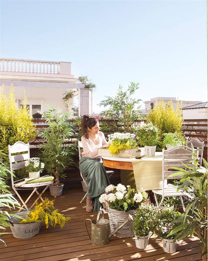 mujer arreglando plantas en terraza del atico 1023x1280