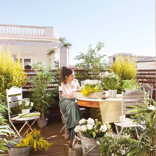 mujer arreglando plantas en terraza del atico 1023x1280