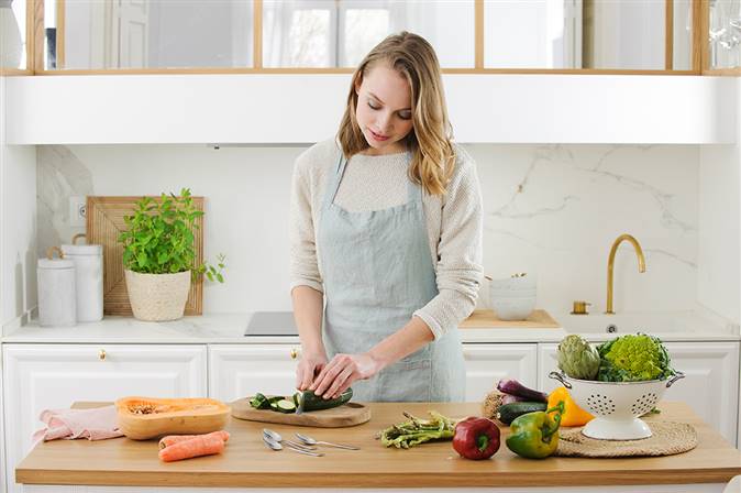 mujer cortando verduras en la cocina