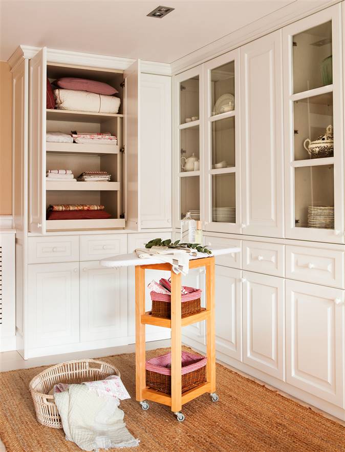 Planchador en blanco con armarios para guardar la ropa y tabla de planchar