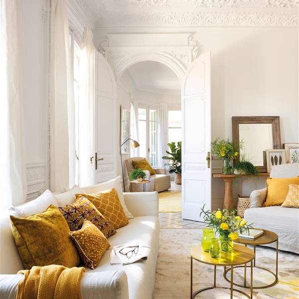Salón blanco con sofá y butaca blanca con cojines amarillos y dorados_ 00454744
