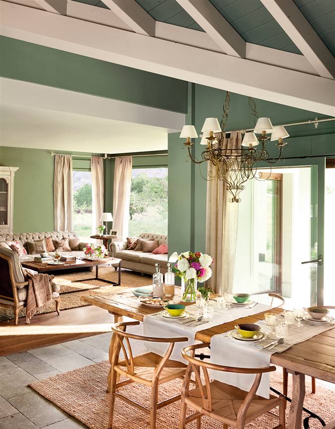 Salón comedor con paredes en verde y techo con vigas vistas