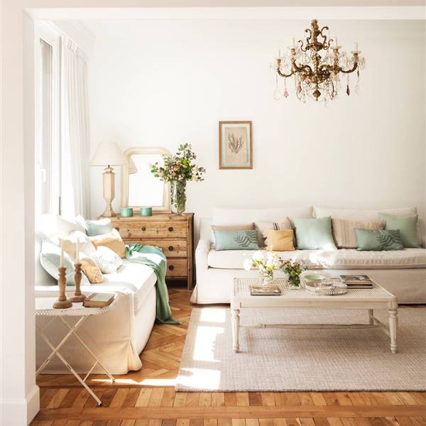 Salón con distintos tipos de parquet sofás blancos comoda madera y lámpara techo araña_458380