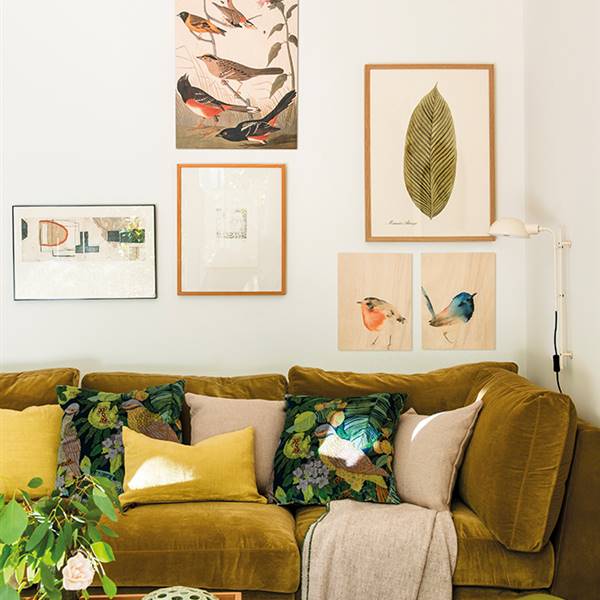 salón con sofá de terciopelo verde y cojines botánicos