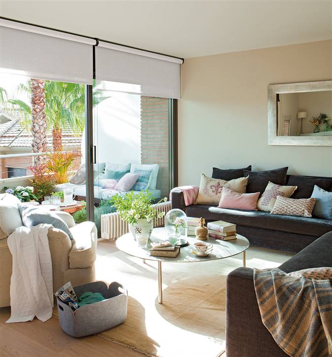 Salón con sofá en L que comunica con una terraza estilo chill out
