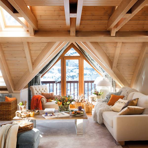 Salón con techo abuhardillado de madera y ventana en tejado