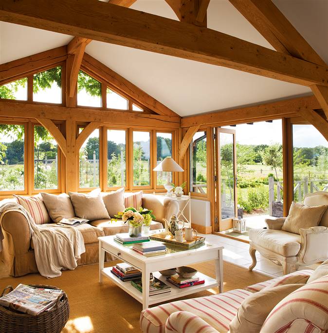 Salón con vigas de madera y ventanales al jardín